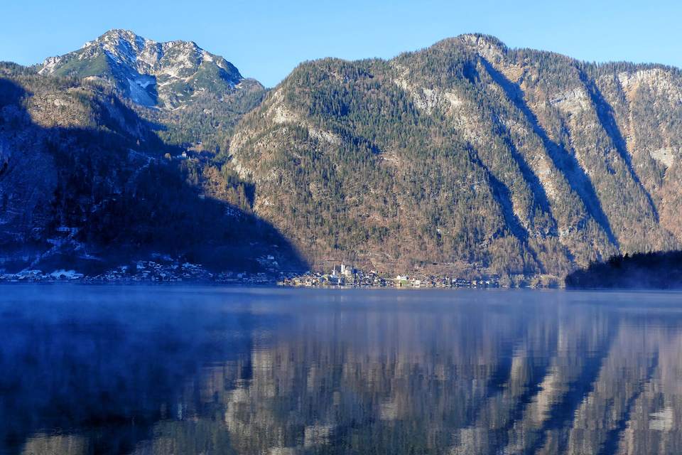 Hallstätter See mit Dunst über dem Wasser, am Ufer Hallstatt, die Berge spiegeln sich im See